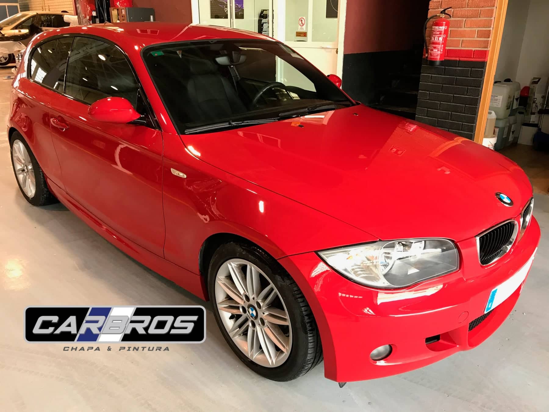 BMW rojo recién reparado en el taller de Car Bros