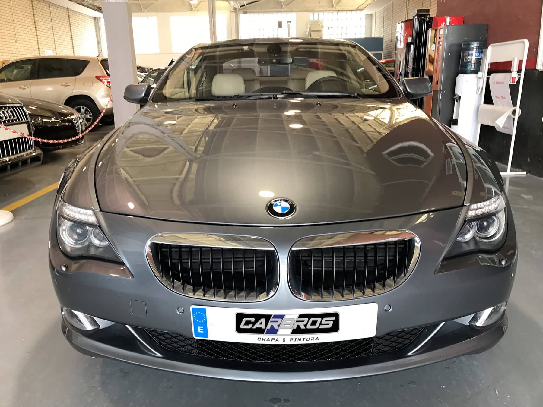 BMW gris oscuro de frente, en el taller