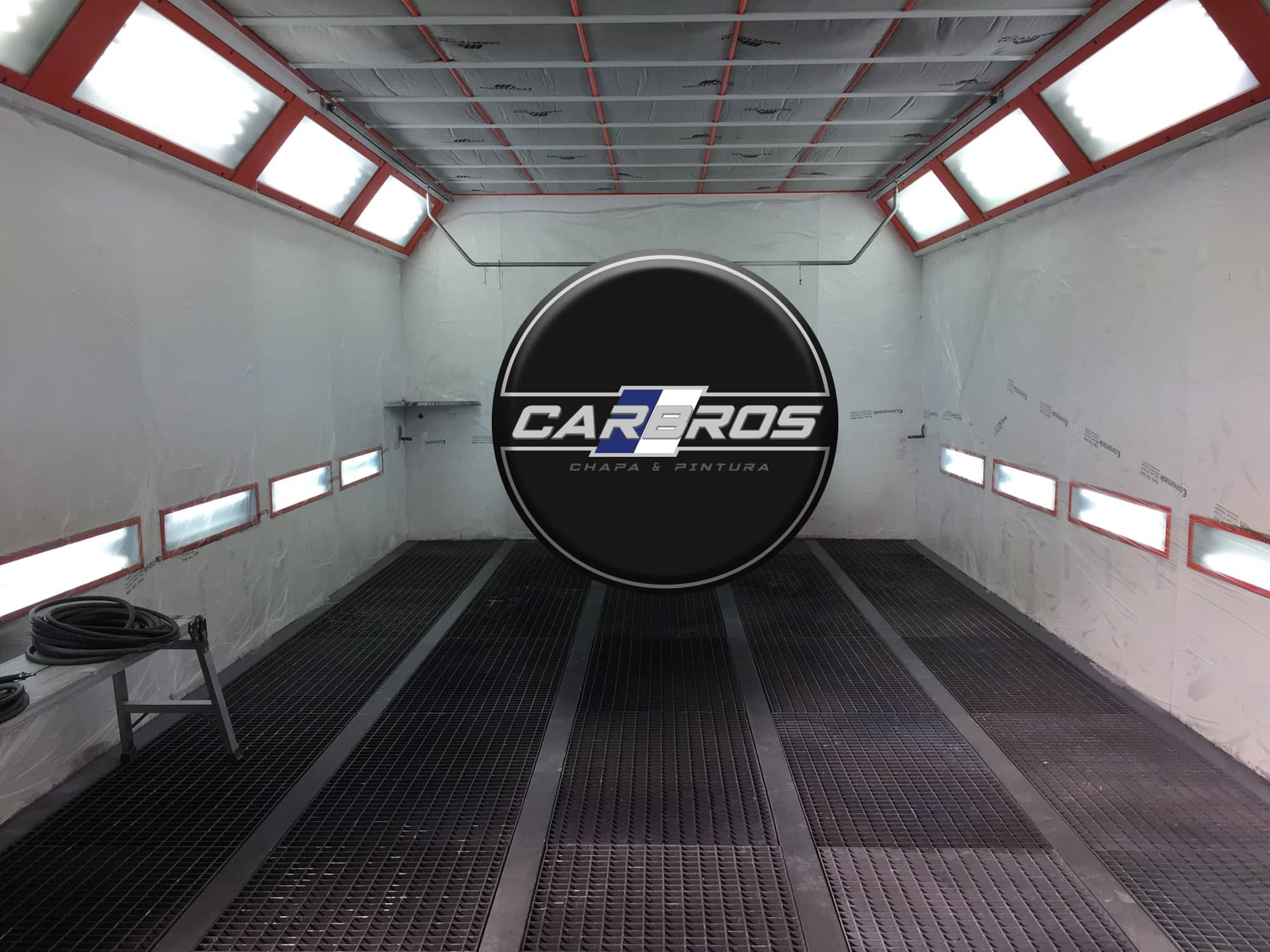 La cabina de pintura de Car Bros, blanca, con su logo al fondo